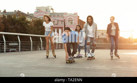 Diverse jugendlich Freunde Reiten auf Skateboards und Walzen Stockfoto