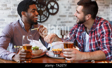 Freunde In Bar, trinken Bier und Essen Pommes Frites Stockfoto