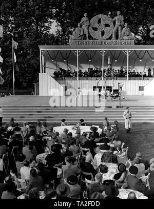 Auf einem Festival der NS-Organisation "Kraft duch Freude' ('Stärke durch Freude") in Treptow, das Festival Besucher mit künstlerischen Darbietungen unterhalten werden, hier eine menschliche Pyramide. Im Hintergrund, eine Tribüne mit einem Music Orchestra. Oben, das Emblem der KdF und der Slogan "Freut euch des Lebens" ( "das Leben genießen"). Stockfoto