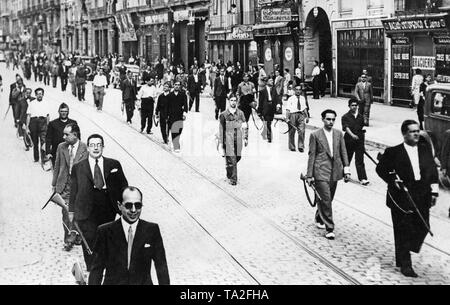 Foto des spanischen Nationalen unterstützer Marching in Zivil oder Uniform bewaffnet mit Karabiner durch das Zentrum von Zaragoza, Aragon, Spanien, nach Ausbruch des Spanischen Bürgerkriegs. Im Hintergrund, Zivilisten sind gerade diese Szene. Die Republikaner versuchten Zaragoza vergeblich im Juli 1936 zu besetzen. Eine weitere Offensive im September 1937 ist fehlgeschlagen. Stockfoto