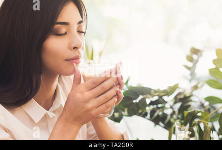 Attraktive asiatische Frau genießen den Duft von Kaffee am Morgen Stockfoto