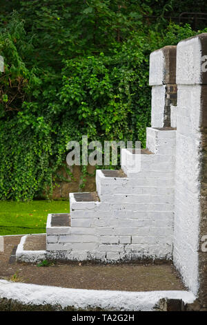 Seitenansicht von Beton Treppen in weiß lackiert. Bäume sind im Hintergrund zu sehen. Stockfoto