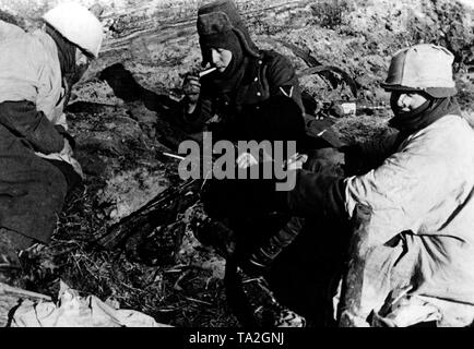 Deutsche Soldaten Rauch in der umgebenen Stadt Demyansk. In einer Pause im Kampf gegen Sie haben Zeit für eine Zigarette. Foto der Propaganda Firma (PK): kriegsberichterstatter Ulrich. Stockfoto