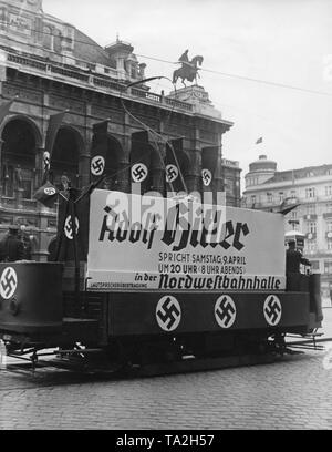 Nach dem Einmarsch der deutschen Truppen in Österreich ein Referendum über die Annexion Österreichs gehalten zu werden an das Deutsche Reich. Eine Straßenbahn Auto fährt durch Wien mit einer Plakatwand. Der Vorstand lautet "Adolf Hitler eine Rede am Samstag, den 9. April, um 20 Uhr (8 Uhr) in der Nordwestbahnhalle'. Stockfoto