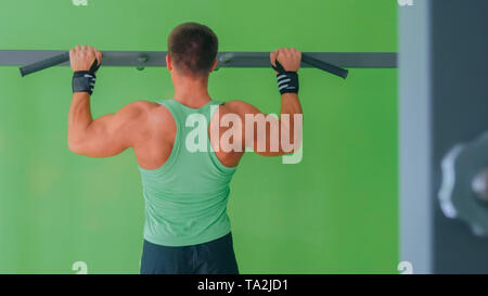 Athletischen jungen Mann tun chin-ups im Fitnessstudio Stockfoto