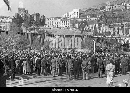 Foto einer Masse Gruß die Marching - Francisco de Borbón y de la Torre, Herzog von Sevilla (in den Rücken, ein Pferd reiten, von 1882 bis 1953) Vor den Ruinen des Castillo Gibralfaro in Málaga, Andalusien, Spanien, im Jahre 1936. Im Vordergrund, Passanten begrüße ihn. Die Straße ist mit spanischen Flaggen dekoriert. Stockfoto