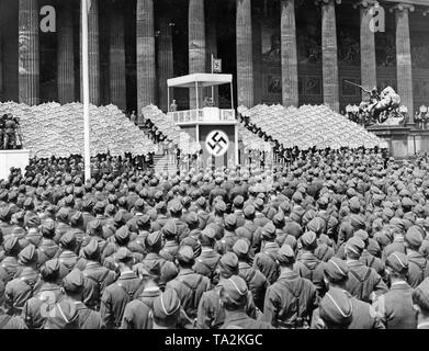 Adolf Hitler in einer Rede unter einem Vordach mit Hakenkreuz während der Zeremonie für die Legion Condor im Lustgarten auf der Museumsinsel am 6. Juni 1939. Neben ihm ist Hermann Goering. Im Vordergrund stehen die aufgereiht Legionäre. Rechts und Links vom Rednerpult sind Hitler Jugend Mitglieder mit Schilder mit den Namen der gefallenen Spanienkaempfer (Personen, die für die in Spanien Links) gekämpft. Auf der linken Seite sind Filmkameras. Adolf Hitler in einer Rede unter einem Vordach mit Hakenkreuz an der staatlichen Zeremonie für die Legion Condor im Lustgarten auf der Museumsinsel am 6. Juni 1939. Stockfoto