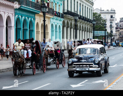 Havanna, Kuba - vom 25. Juli 2018: Pferd und Buggy, die Touristen durch die Straßen der Altstadt von Havanna Stadt zusammen mit klassischen amerikanischen Autos als verwendet Stockfoto