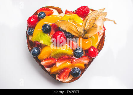 Herzförmige Frucht Biskuitteig, Obstkuchen auf weißem Hintergrund auf Tisch. Gesunde Süßwaren Hintergrund. Stockfoto