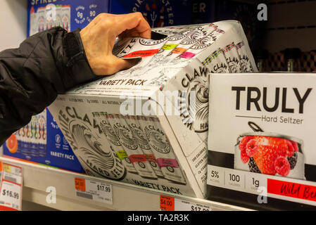 Eine anspruchsvolle Verbraucher entscheiden sich für einen Fall von Weiße Kralle Marke hart Seltzer unter anderen Marken in einen Kühler in einem Supermarkt in New York am Montag, 13. Mai 2019. Analysten prognostizieren, dass 2019 die Sommer hart Seltzer, wie eine Reihe von großen Bier Brauereien werden Sie in den Raum sowie zahlreichen kleinen Brauereien. (Â© Richard B. Levine) Stockfoto