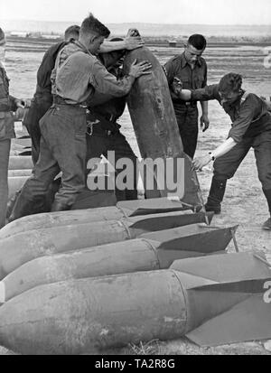 Foto von Soldaten des Bodenpersonals der Legion Condor beim Laden von 250 kg Antenne Bomben auf einem Flugplatz der Legion Condor in Spanien. Stockfoto