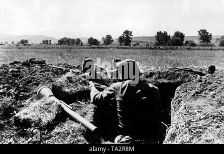 Ungarische Soldaten nahmen Positionen auf der Vorderseite zwischen der Theiß und der Donau. Eine deutsche Panzerfaust ist nahe am Rand des Grabens. Stockfoto