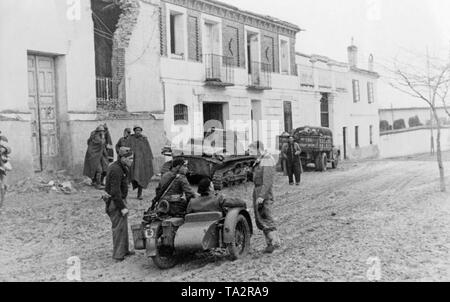 Nach der Eroberung von Malaga und mortil am 8. Februar 1937, spanischer Staatsangehöriger motorisierte Einheiten, die unter allgemeinen Gonzalo Queipo de Llanos setzten ihren Marsch in Richtung Almeria. Im Vordergrund, ein Motorrad mit Seitenwagen. Im Hintergrund, einem Deutschen gepanzerten Fahrzeug I (PzKpfw I) und einem Lkw, der von Soldaten umgeben ist. Im Hintergrund, ein teilweise zerstörten Straße. Stockfoto