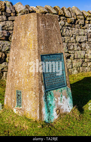 Trig Point auf dem Gipfel der Ros-Hügel, mit Plakette markiert den Standort der Ros Schloss Eisenzeit Hill fort. In der Nähe von chillingham, Northumberland, Großbritannien. November 2018. Stockfoto