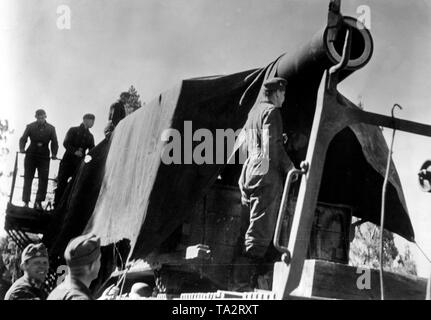 Deutsche Soldaten Tarnung, die Railroad gun 28-cm-Kanone 5 (E) ein, bei dem die umgebenen Stadt Brände. Foto der Propaganda Firma (PK): SS Kriegsberichterstatter Raudies. Stockfoto