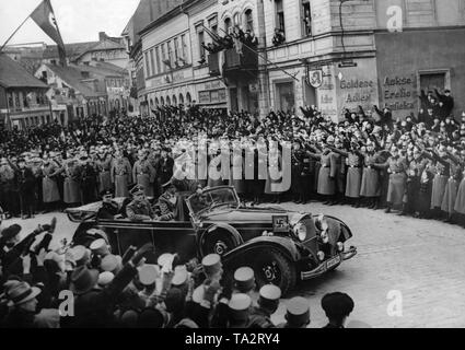 Adolf Hitler ist Fahren triumphierend durch die Stadt Memel (Klaipeda) in einem Mercedes, hier in die Werftstraße, wo er von der Bevölkerung für die Aufnahme der Memelländischen in das Deutsche Reich bejubelt wird. Hinter im Auto an der Linken, Generaladmiral Erich Raeder. Stockfoto