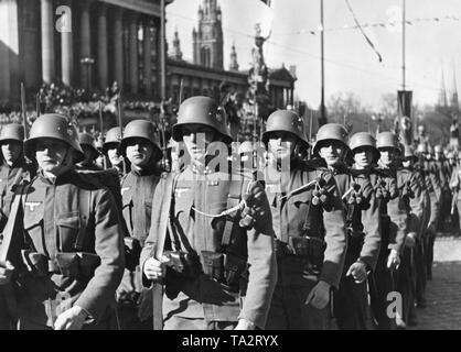 Österreichische Soldaten paradieren vor Adolf Hitler vor dem Parlamentsgebäude in Wien. Die Soldaten tragen den Deutschen Reichsadler mit Hakenkreuz. Feierlichkeiten finden in Wien im Zuge der "Anschluss" Österreichs an das Deutsche Reich. Stockfoto