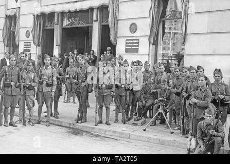 Spanische Soldaten stellen stark während der Putsch gegen die Zweite Spanische Republik vor einem Gebäude der staatlichen Telefongesellschaft im Zentrum von Madrid am 18. Juli 1937 bewaffnet. Auf der rechten Seite im Vordergrund, einem französischen Hotchkiss M 1914 Maschine Gewehr auf eine Waffe der Beförderung. Es sind Mitarbeiter, die im Hintergrund. Stockfoto