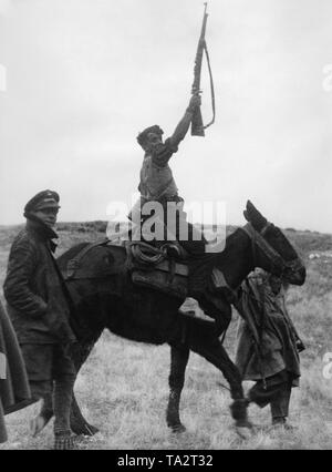 Foto von drei spanischen nationalen Kämpfer an der Front von Madrid im Februar 1937. Ein Kämpfer sitzt auf einem Maultier und hält seine Waffe (Gewehr 98) hoch in der Anrede. Stockfoto