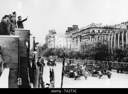 Foto der luxuriösen Stadtteil Paseo de la Castellana in Madrid während der großen siegesparade der Spanischen Truppen in Madrid am 19. Mai 1939. Auf der linken Seite in den Rand des Fotos, das Caudilo General Francisco Franco (auf der rechten Seite mit seinem Arm angehoben) und Generalmajor Freiherr Wolfram von Richthofen zusammen mit anderen hohen Beamten der Inspektion der Parade von der Bühne. Auf der rechten Seite, ein anti-aircraft Unit verunreinigt (Krupp L2H143 Traktor mit 2cm Flak 30). Stockfoto