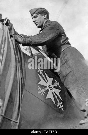 Foto eines deutschen Soldaten des Bodenpersonals, der eine Messerschmitt Bf 109 während der Schlachten von England deckt im Oktober 1940. Auf dem Display der Spanischen Kreuz, das von Adolf Hitler im Spanischen Bürgerkrieg 1939 bis die Kämpfer der Legion Condor ausgezeichnet wurde. Stockfoto