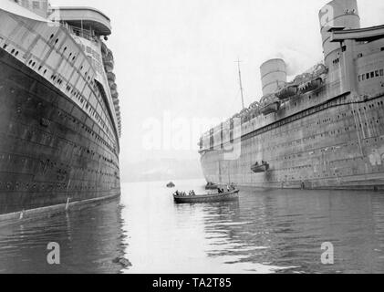 Besatzungsmitglieder der 'Queen Elizabeth' (r) Praxis die Freigabe der Rettungsboote. Im Bild links ist die Französische Passagierschiff "Normandie". Stockfoto