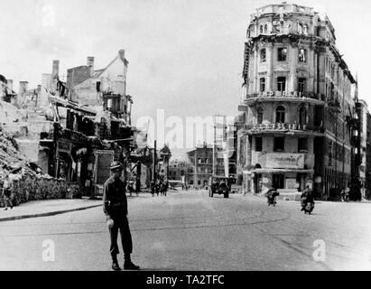 Ein amerikanischer GI steuert Verkehr an der zerbombten Karlsplatz in München. Im Hintergrund, die älteste Kontorhaus (Bürogebäude) in München. Stockfoto