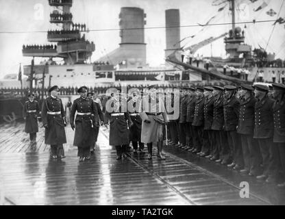 Paul von Hindenburg besucht Truppen der Reichsmarine anlässlich einer Besichtigung, mehrere Schiffe im Hintergrund vor Anker liegen. Stockfoto