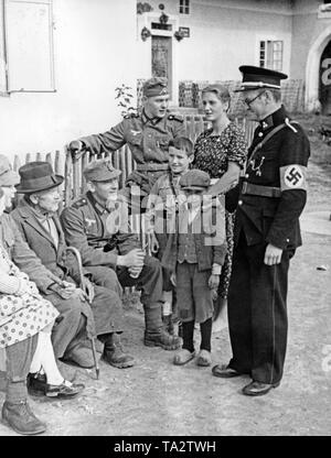 Ein Polizeioffizier (rechts), eine deutsche Berg trooper und ein Bewohner in einem Gespräch, das am 4. Oktober 1938 in Oberplan (Horni Plana). Kinder stehen zwischen Ihnen. Der Polizist trägt eine Tschechische einheitliche und ein Hakenkreuz Armbinde. Stockfoto