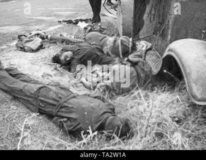 Foto von einer Crew von Artilleriefeuer während der Schlacht von Talavera de la Reina 85 Kilometer von Madrid getötet. Die Toten sind das Tragen der blauen Overall der Republikanischen Milizen. Auf der rechten Seite, ein Teil der Karosserie des Tanks, auf die über Links, die Straße geteert. Stockfoto