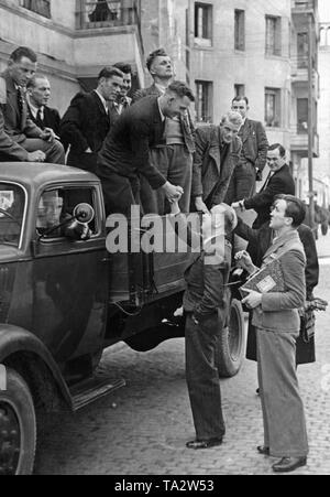 Foto von einer Gruppe von ausscheidenden Soldaten der Legion Condor auf der Ladefläche eines Opel Blitz Lkw nach dem Ende des Spanischen Bürgerkriegs (April 1939) Kurz vor ihrer Abreise im Mai, 1939. Die Soldaten sind das Tragen ziviler Kleidung, die an sie übergeben wurden, bevor Sie nach Hause gereist. Andere Soldaten nehmen Abschied von ihren Kameraden. Stockfoto