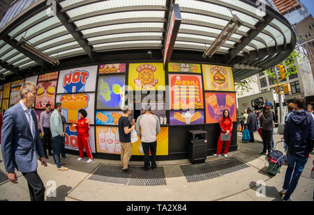 Die Teilnehmer bis zu gefilmt, die versuchen, Proben von Erzeugnissen, die von der fiktiven Firma "n Kaufen Groß", in Midtown Manhattan in New York am Mittwoch, 8. Mai 2019. "N kaufen Große" ist ein fiktives Unternehmen in mehreren von Pixar Filme wie "Wall-E" verwendet. (© Richard B. Levine) Stockfoto