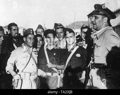 Foto von einer Gruppe von Soldaten im Gespräch mit dem republikanischen Kriegsminister, General Jose Asensio Torrado (ganz rechts mit Regenschirm) in Toledo. Dritter von links, im hellen Bereich Tunika, ein TENIENTE (Offizier, Lieutenant), dritter von rechts, ein SARGENTO (sergeant). Stockfoto