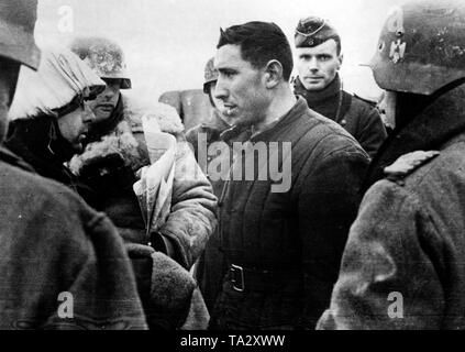 Ein sowjetischer Offizier, der während der Kämpfe an der Moskauer gefangen genommen worden war, ist von einem deutschen Offizier der Wehrmacht verhört. Andere Soldaten stehen um ihn herum. (PK Foto: Krieg Reporter Tepper). Stockfoto