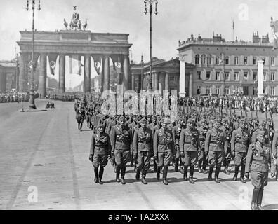 Foto einer Bildung von Soldaten (Pilot Offiziere in der ersten Zeile, hinter Unteroffiziere und Crew) der Legion Condor paradieren am Pariser Platz (Unter den Linden) in Richtung Lustgarten anlässlich Ihrer Rückkehr aus Spanien am 6. Juni 1939. Im Hintergrund das Brandenburger Tor mit Hakenkreuzfahnen und der Spanischen Bandera. Auf dem Horizont am Ende der Ost-West-Achse (ehemalige Charlottenburger Chaussee) die Siegessäule am Großen Stern (Großer Stern). Stockfoto