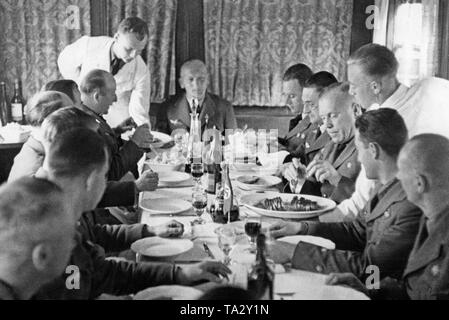 Foto von der Offiziere zu Mittag im Diner des Wohnzug (Sonderzug) der Legion Condor im Spanischen Bürgerkrieg bei Toledo Bahnhof, 1939. Kommandant Major General Wolfram Freiherr von Richthofen ist am Ende der Tabelle sitzt. Kellner in weißen Uniformen servieren Braten. Stockfoto