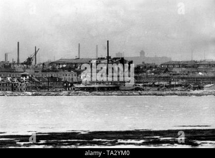 Blick auf die Stadt umgeben durch ein Fernglas. Im Vordergrund die Werftanlagen. Foto der Propaganda Firma (PK): kriegsberichterstatter Freytag. Stockfoto