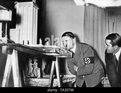 Adolf Hitler sieht das Modell des Deutschen Pavillons für die Weltausstellung in Paris im Jahre 1937. Neben ihm steht der zuständigen Architekten Albert Speer. Stockfoto