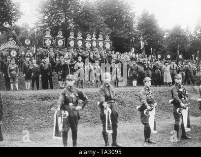 Adolf Hitler eine Rede an der Reichsparteitag in Nürnberg. Hinter ihm ist die Oberste SA-Chef Franz Pfeffer von Salomon, zu seiner Linken Julius Streicher und Rudolf Hess. Im Vordergrund sind Messing Spieler. Stockfoto