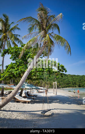 Insel Phu Quoc, Vietnam - 31. März 2019: Der Strand ist schneeweiß, Überhängende Palmen mit Schaukeln. Urlauber Touristen unter den Sonnenschirmen Stockfoto