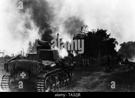 Panzer 35 (t) des 6. Panzerdivision auf dem Vormarsch durch ein brennendes Dorf an der Ostfront. Bereich Army Group North. Stockfoto