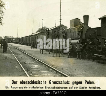 Soldaten der Grenztruppen, der Freikorps Mitglieder, posieren vor einem gepanzerten Zug am Bahnhof in Kreuzburg (kluczbork) während der ersten polnischen Aufstand in Oberschlesien. Stockfoto