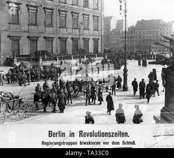 Im Zuge der Berliner Maerzkaempfe (März kämpft) im Jahr 1919 wurde von der Regierung loyalen Soldaten vor dem Berliner Stadtschloss gesammelt. Ein weißes Totenkopf und der Aufschrift "Nieder mit Spartakus" (Unten mit Spartacus) ist auf einem Wagen lackiert. Auf der rechten Seite ist ein Teil der nationalen Kaiser-Wilhelm-Denkmal. Stockfoto