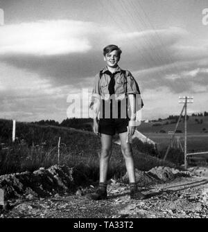 Ein Mitglied des deutschen Jungvolk von Gau Ostberlin ist Wandern auf einer Landstraße. Stockfoto