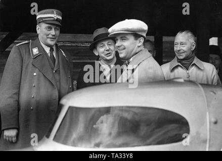 Von links: Obergruppenfuehrer und Adjutant Hitlers, Wilhelm Bruckner (in Uniform), der Rennfahrer Rudolf Caracciola (white Beret) und Kronprinz Wilhelm von Preußen (ohne Kopfbedeckung). Das Bild zeigt die drei kurz vor einem neuen Rekordversuch Caracciola mit seinem Mercedes auf der Berliner Automobil-Verkehrs- und uebungsstrasse (AVUS). Stockfoto