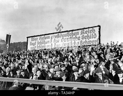 Blick auf eine Tribüne während einer Rede gehalten von Konrad Henlein in Aussig (Ústí nad Labem) am 16. Oktober 1938. Das Publikum führt den Hitlergruß. Hinter, über der Plattform, ein Banner. Auf den Banner: "Der deutschen Schild und das deutsche Schwert liegen über größere Deutschland'. Stockfoto