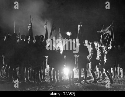 Jungen und junge Männer rund um ein Lagerfeuer versammelt bei einer Feier der Buendische Jugend auf dem Eichberg in der Nähe von Saarmund anlässlich der Volkstrauertag (volkstrauertag). Stockfoto