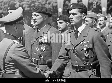 Generaloberst Walther von Brauchitsch unterscheidet Kämpfer der gepanzerten Korps (Totenkopf, Panzer Assault Badge, Gruppe Imker) der Legion Condor. Ein leutnant (auf der rechten Seite, mit der Wehrmacht lange Service Award) wird gerade begrüßt. Auf der linken Seite gibt es einen Kapitän (Eisernes Kreuz 1.Klasse, Krieg Verdienst Kreuz Erste Welt Krieg und Wehrmacht lange Service Award). Stockfoto