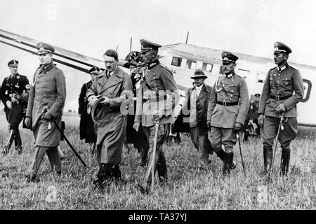 Adolf Hitler auf dem Flugplatz der Marienburg in Ostpreußen, im Hintergrund sein Flugzeug, eine Junkers Ju 52. Hitlers Plan ist die Deckung auf die Unterdrückung der "röhm Putsch" mit Reichspräsident Paul von Hindenburg. 3. von rechts, Heinrich Hoffmann. Stockfoto