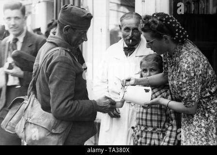 Soldaten, die bereits im Ersten Weltkrieg teilgenommen haben, werden aus der deutschen Gefangenschaft freigelassen werden. Hier, nach der Ankunft in Chalon-sur-Marne. Eine Frau gibt Wasser. Stockfoto